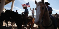 A protester waves the U.S. flag near the Bureau of Land Management's base camp where seized cattle, that belonged to rancher Cliven Bundy, are being held at near Bunkerville