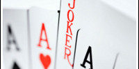 Playing cards: Four aces and a joker over a background